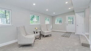 A spacious room with two chairs, a small table, and a door. - Blue Bungalow! Wonderful 4-bedroom house in charming Augusta (Augusta)