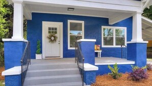 A house with a blue exterior, white trim, a front door with a wreath, two windows, and a small porch with steps. - Blue Bungalow! Wonderful 4-bedroom house in charming Augusta (Augusta)
