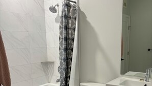 Ein Badezimmer mit Dusche, Toilette und Waschtisch.