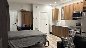 Eine kleine Küche mit Holzausstattung, integriertem Mikrowellenherd und Kühlschrank.