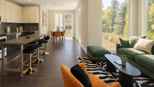 A modern kitchen with a dining area, a green sofa, and a view of trees through large windows. - Chevy Chase  301  2BR (Chevy Chase)