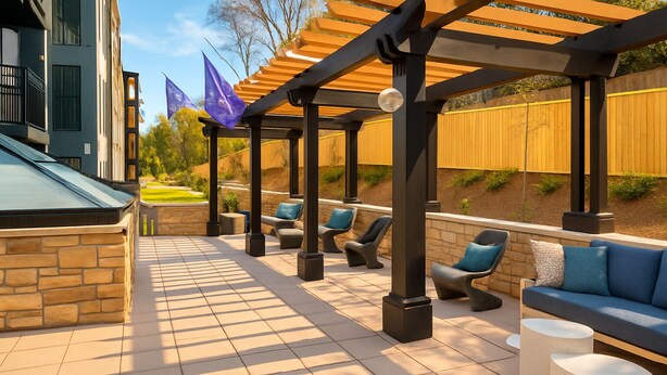 Un patio al aire libre con muros de piedra, una pérgola y mobiliario exterior.