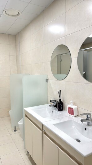 A modern bathroom with two sinks, a mirror, and a toilet. - STAYUP ILSAN Capsule Hotel (Goyang)