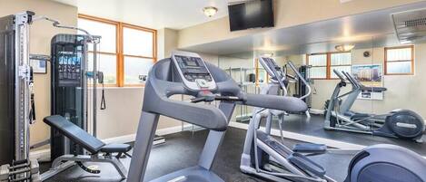 A gym with treadmills, a weight bench, and a squat rack.