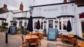 The Abbey Field pub with outdoor seating, a sign indicating it is a pub, and a notice about upcoming renovations. - Milsoms Hotel (Kenilworth)