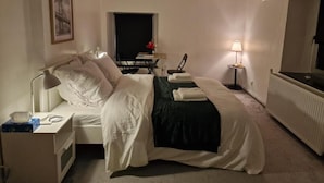 A hotel room with a bed, bedside table, lamp, and a mirror. - The Famenne Escape (Marche-en-Famenne)