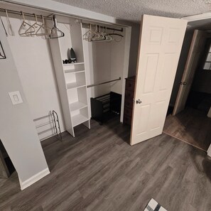 A walk-in closet with open doors, a shoe rack, and a small storage unit.