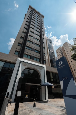 Un edificio alto de diseño moderno, cielo despejado y un cartel con el número 2163.