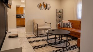 A living room with a sofa, armchair, coffee table, and decorative wall art. - 3BR Near West Point | Coffee Bar | Sleeps 6 (Highland Falls)