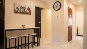 A hallway with a marble floor, a clock, a painting, and a door. - 3BR Near West Point | Coffee Bar | Sleeps 6 (Highland Falls)