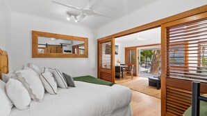 A bedroom with a bed, pillows, a mirror, and a sliding door leading to a balcony. - Absolute Beachfront | Palm Cove Apt Sleeps 4 (Palm Cove)