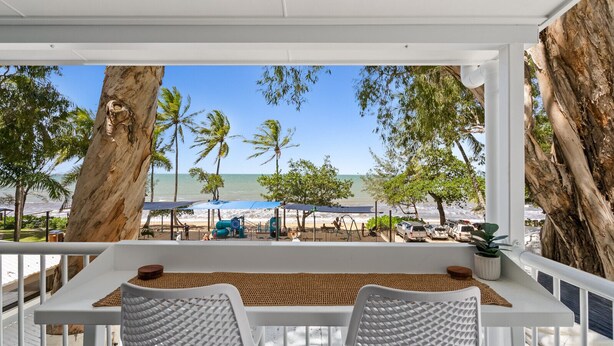 A balcony with a view of the beach, palm trees, and a white railing. - Absolute Beachfront | Palm Cove Apt Sleeps 4 (Palm Cove)