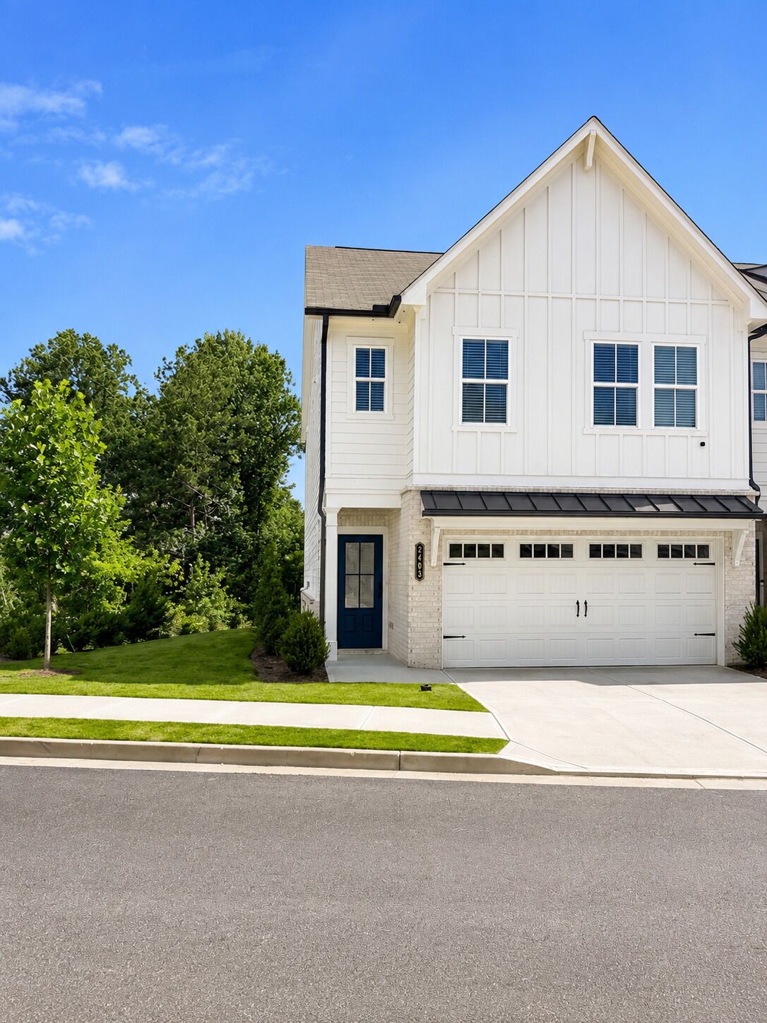A two-story house with a garage, a front door, and a driveway.