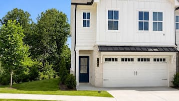 A two-story house with a garage, a front door, and a driveway.