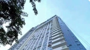 A high-rise building with a modern glass facade, multiple balconies, and a landscaped entrance area. - Luxury Studio in 38 Park Ave IT PARK (Lapu-Lapu)