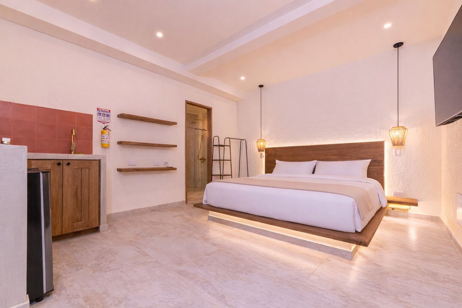Une chambre à coucher avec un lit, des armoires en bois, une douche et un téléviseur.