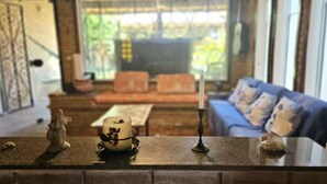 Un salon avec un canapé, une table et des objets décoratifs disposés sur une cheminée.