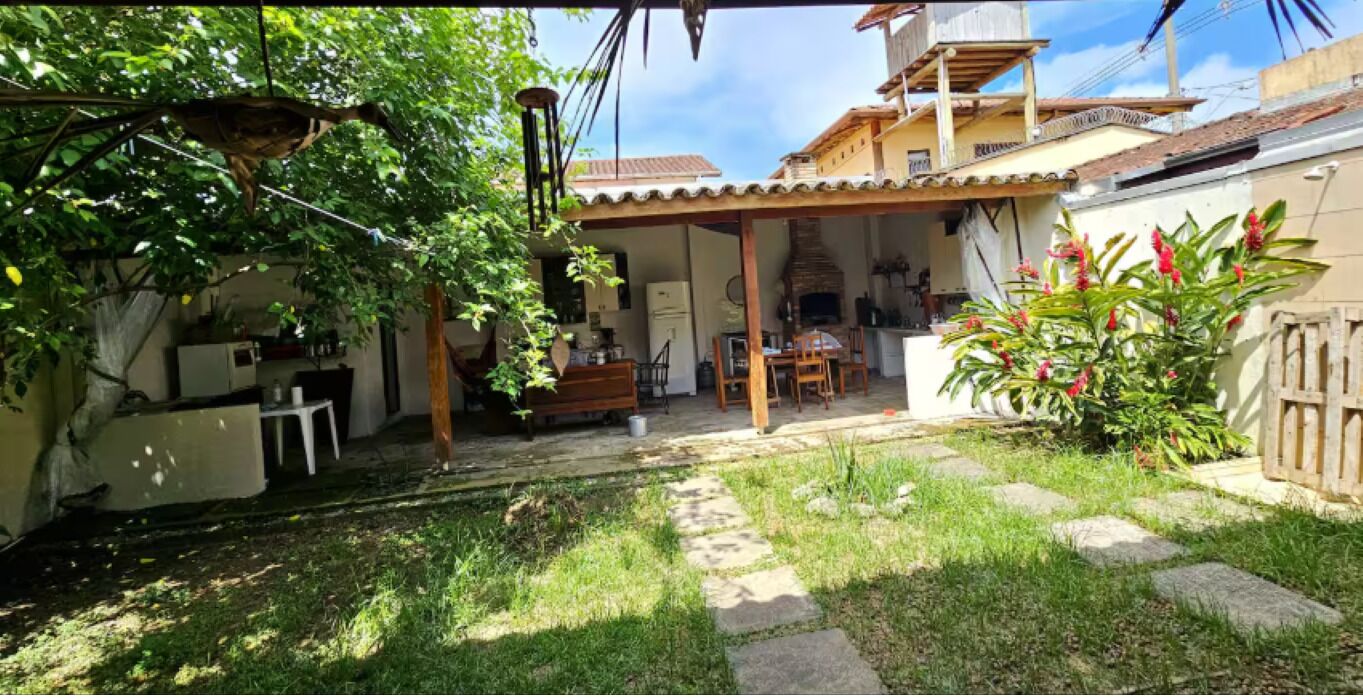 Un espacio al aire libre techado con patio, mobiliario y jardín.