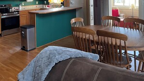 A spacious kitchen with wooden beams, a dining area with a table and chairs, and a cozy seating area with a couch.