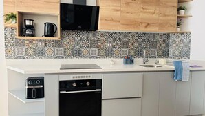 Eine moderne Küche mit Einbauofen, Kaffeemaschine und Mikrowelle.