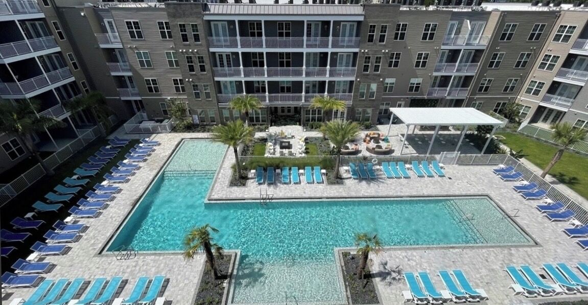 Un hôtel doté d’une piscine, de plusieurs balcons et de chaises longues.