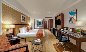 A hotel room with a bed, desk, chair, and a small table. - The Fern Residency Satara Maharashtra (Satara)
