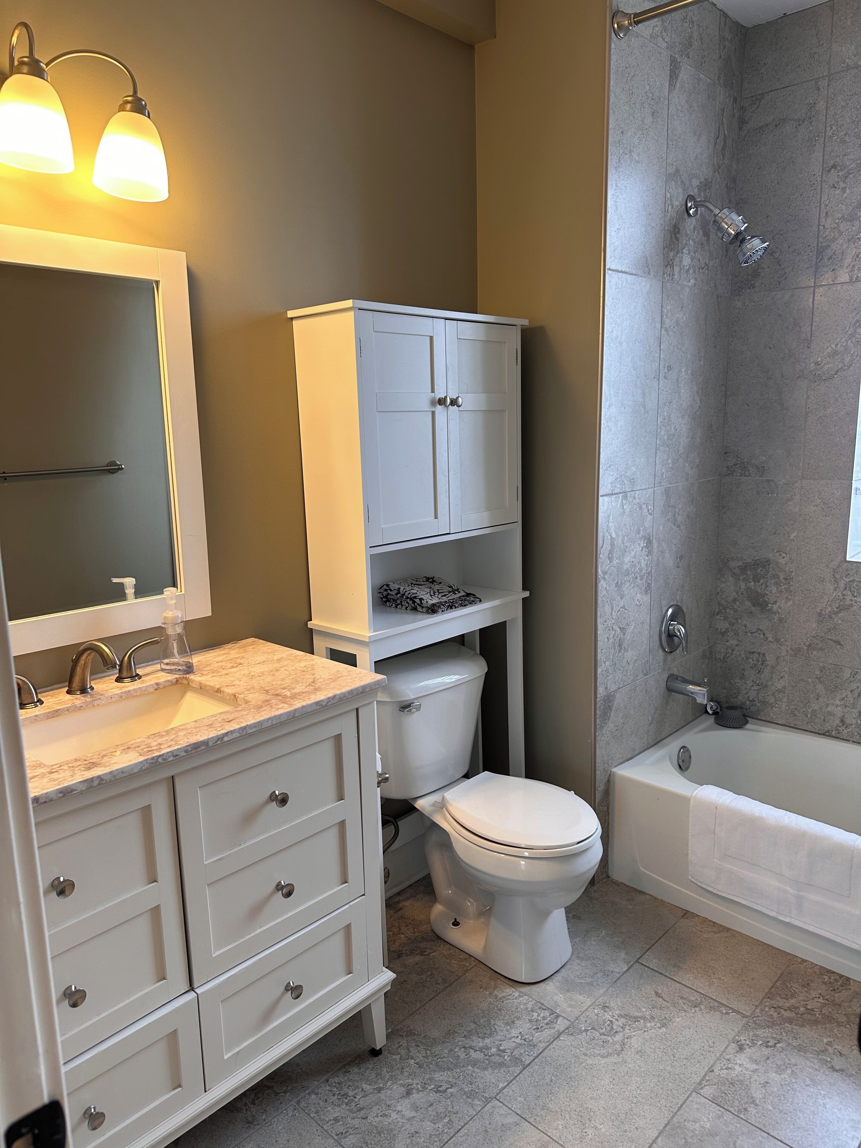 Ein Badezimmer mit Toilette, Waschbecken, Waschtisch und Badewanne.