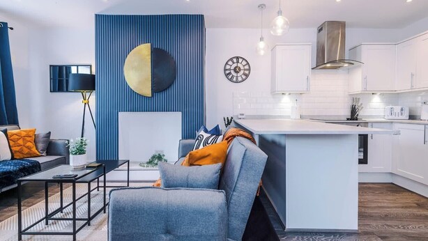Un soggiorno moderno con un divano, un tavolino da caffè e una parete decorata in blu.