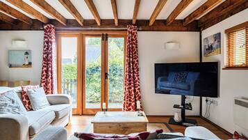 A cozy living room with a sofa, a coffee table, and a television.