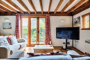 A cozy living room with a sofa, a coffee table, and a television.