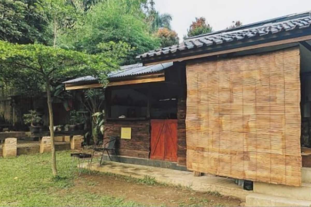 A traditional house with a tiled roof, a wooden door, and a covered porch area.