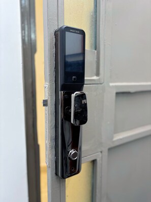 A smart lock installed on a door, featuring a keypad and a card reader.