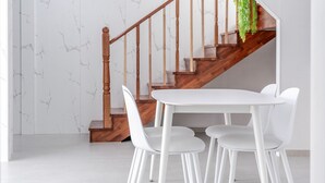 A staircase with wooden railings and a white table with chairs. - Yeongheungdo Jeongwonstay (Incheon)