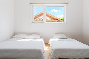 A room with two beds, a window with a view of a wooden structure, and white walls. - Gangneung Ujin Pool Villa (Gangneung)