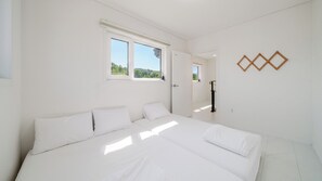 Un dormitorio con una cama grande, una ventana y una puerta.