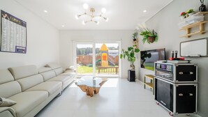 A modern living room with a sofa, a glass coffee table, a TV, and a sound system. - Gangneung Ujin Pool Villa (Gangneung)