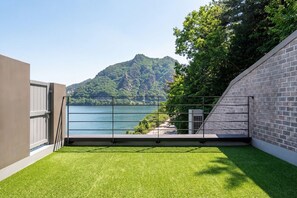 A modern building with a balcony overlooking a lake and a mountain. - Chuncheon Rabbit Star Pension (Chuncheon)