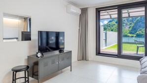 A modern hotel room with a large window, a flat-screen TV, a minibar, and a small stool. - Chuncheon Rabbit Star Pension (Chuncheon)