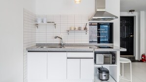 A modern kitchen with white cabinetry, a stainless steel sink, a built-in microwave, and a gas stove. - Chuncheon Rabbit Star Pension (Chuncheon)
