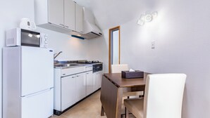 A compact kitchen with a refrigerator, microwave, stove, and cabinets. - Uruma Dome Okinawa Saturn7 (Uruma)