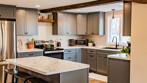 Een moderne keuken met een centraal eiland, barkrukken en een houten plafond.