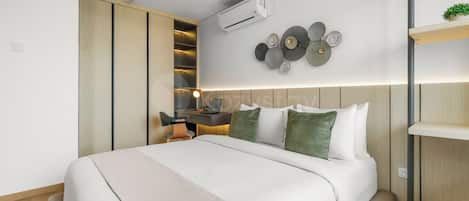 A modern bedroom with a bed, a desk, and a wardrobe.
