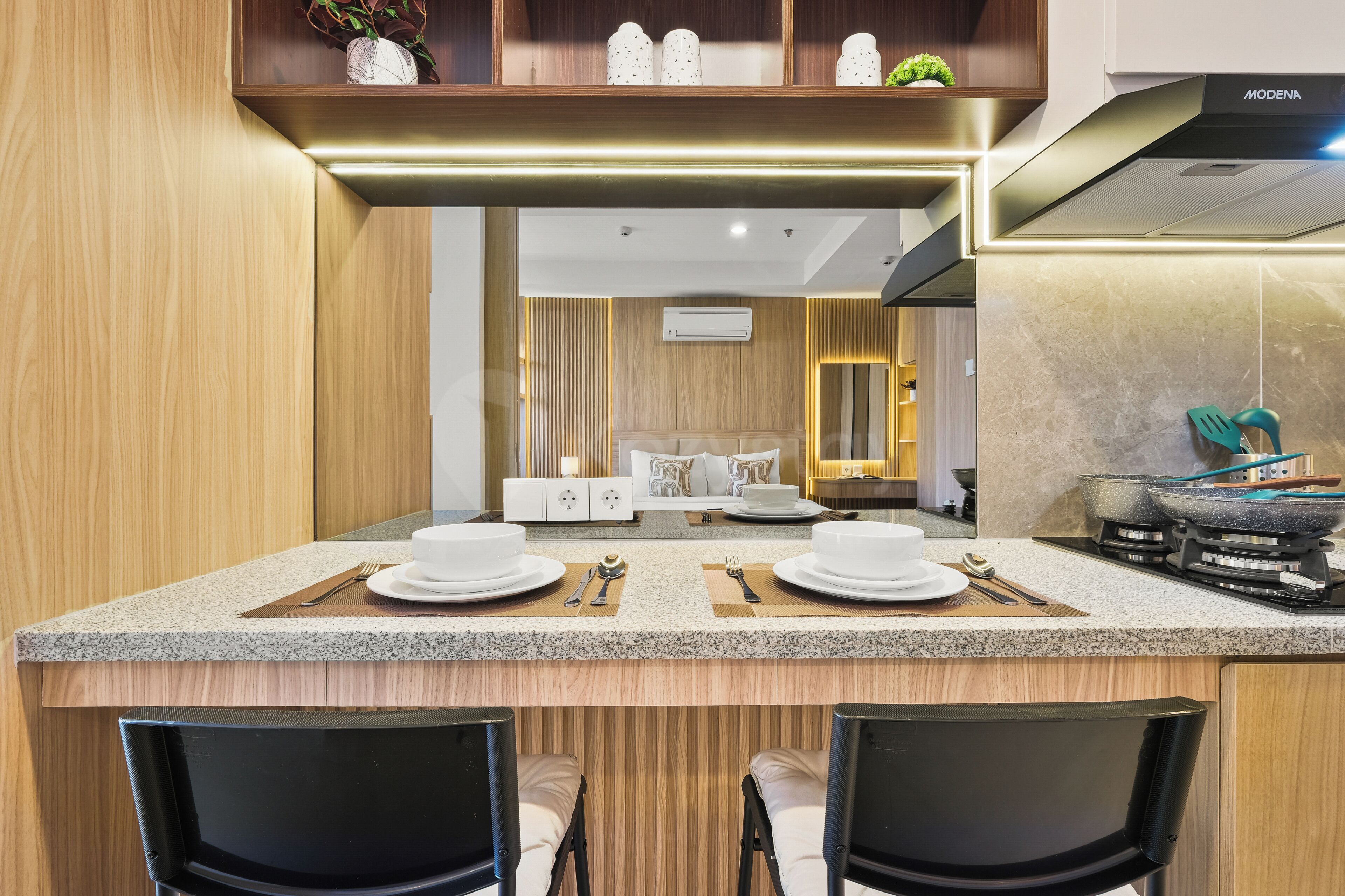 A modern kitchen with a central island, a dining area with two chairs, and a built-in stove.