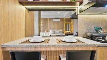 A modern kitchen with a central island, a dining area with two chairs, and a built-in stove.