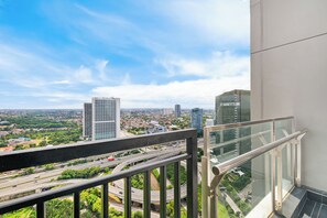 Un balcone con vista sulla città, che include grattacieli e un'autostrada.