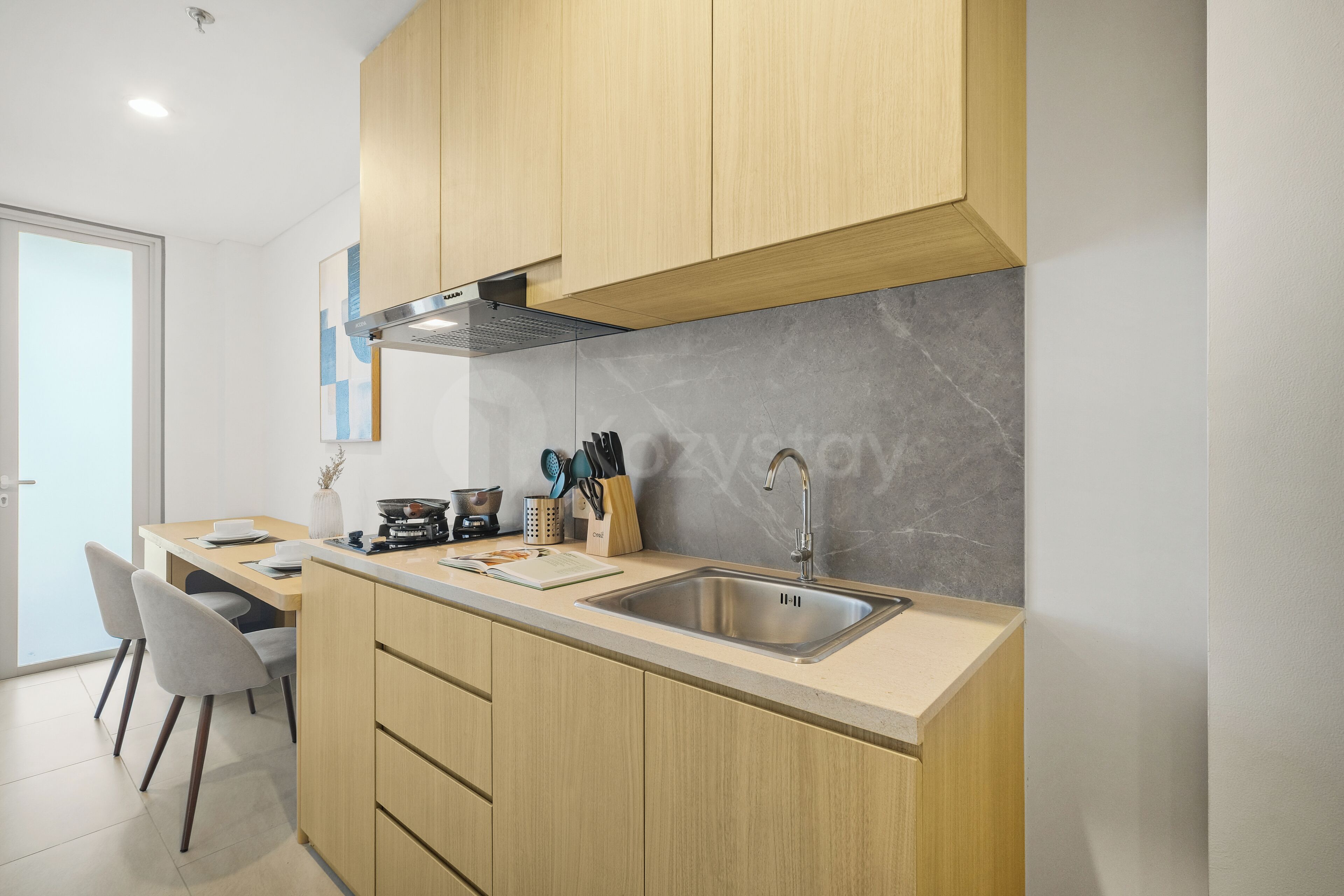 A modern kitchen with wooden cabinets, a stainless steel sink, and a built-in stove.