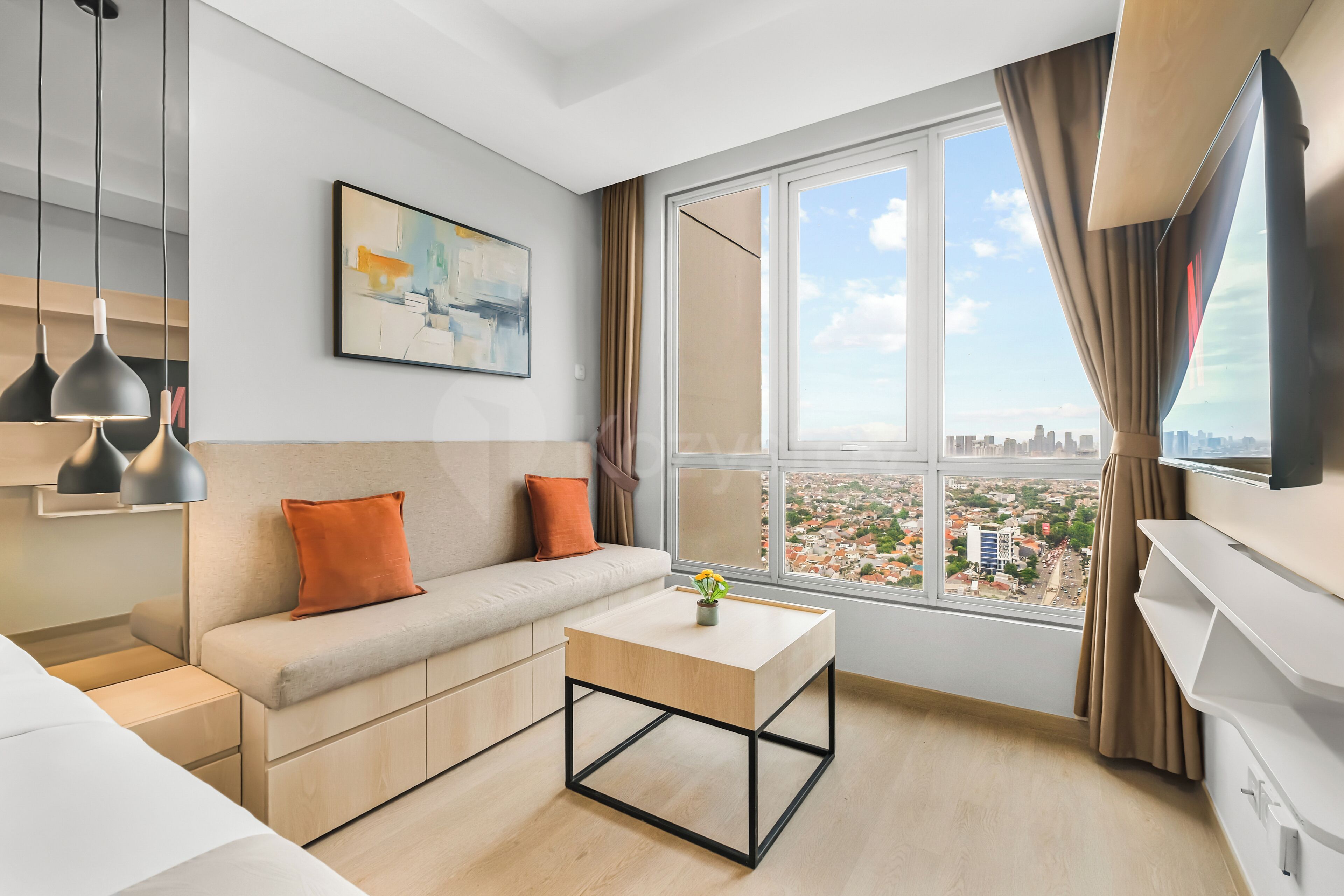 Un salon moderne avec un canapé, une table basse et une grande fenêtre donnant sur la ville.