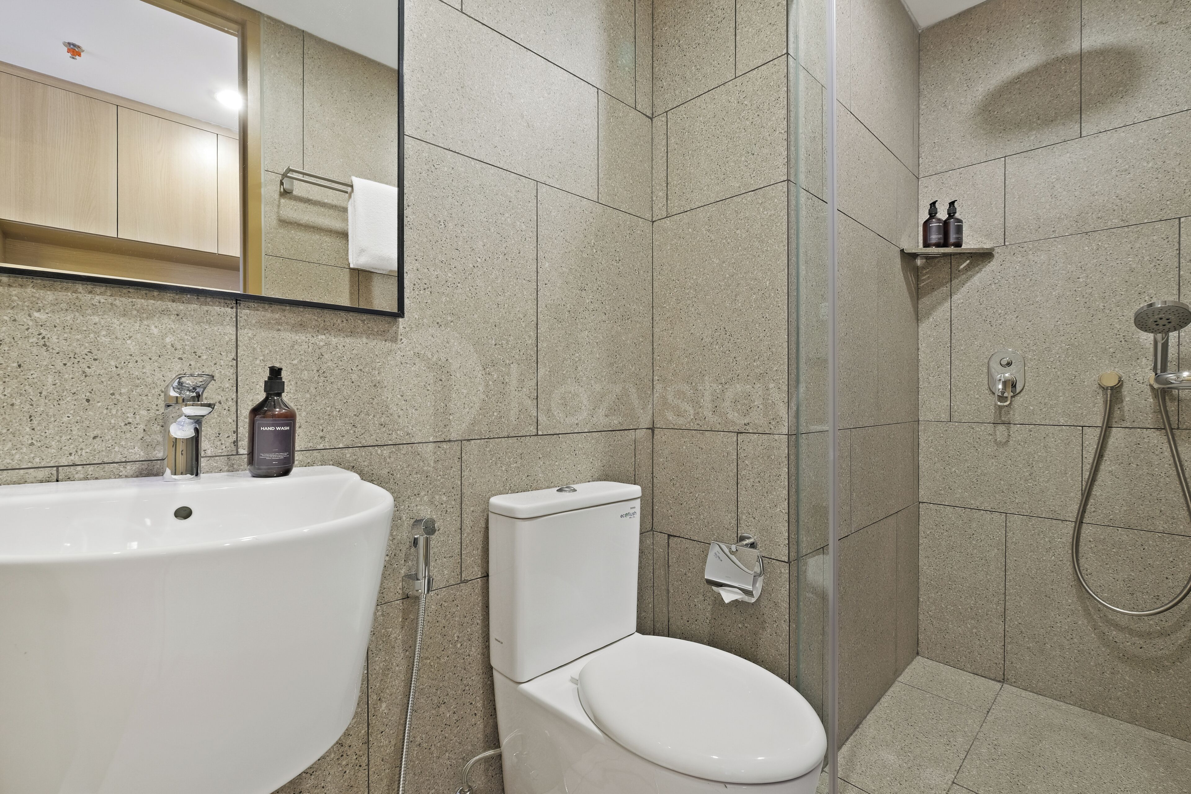 A modern bathroom with a large sink, toilet, and shower area.