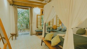 Un dormitorio con cama, banco y vistas al exterior.