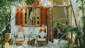 Un interior acogedor con muebles de madera, una escalera y la vista de un niño jugando afuera.